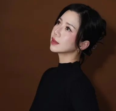 Grace Embury in a black turtleneck against a cocoa backdrop